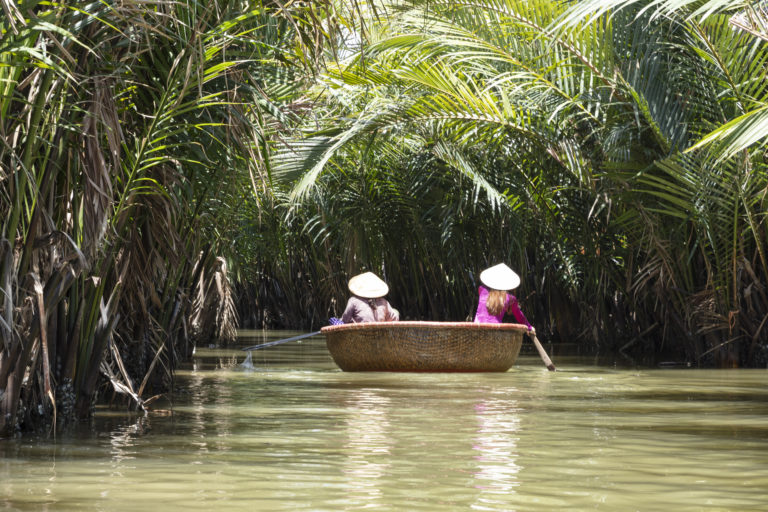 Navigating river in a boat, discovering local ways, away from tourist paths