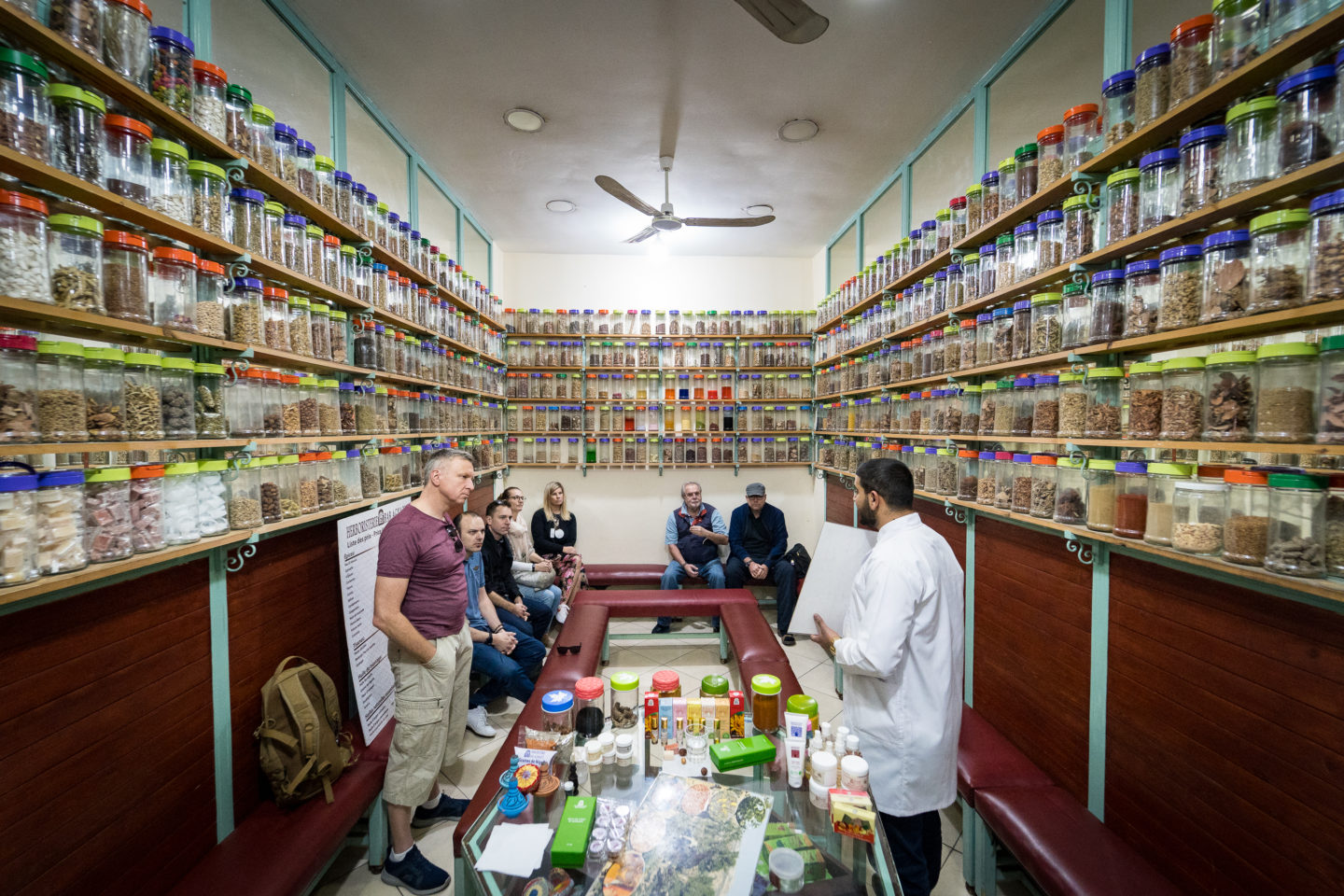 Group of people exploring a spice workshop, surrounded by jars