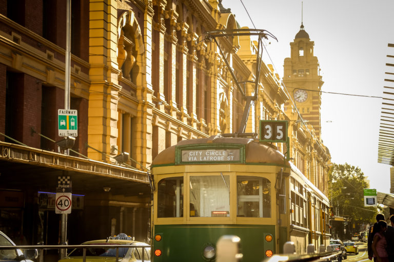 A classic tram passing through a bustling city center