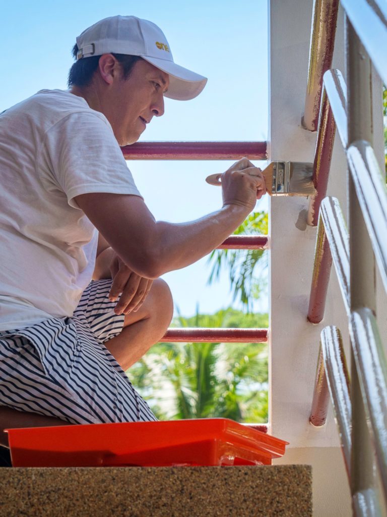 A man paints stairs during a CSR event in Phuket.