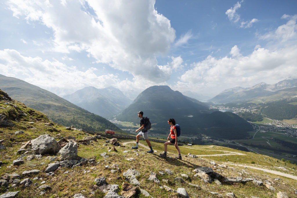 Two people hiking up to Muottas Muragl.