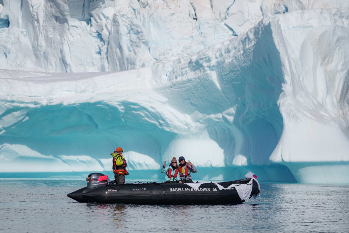In the vast, icy landscape, a small motor raft with a couple on board