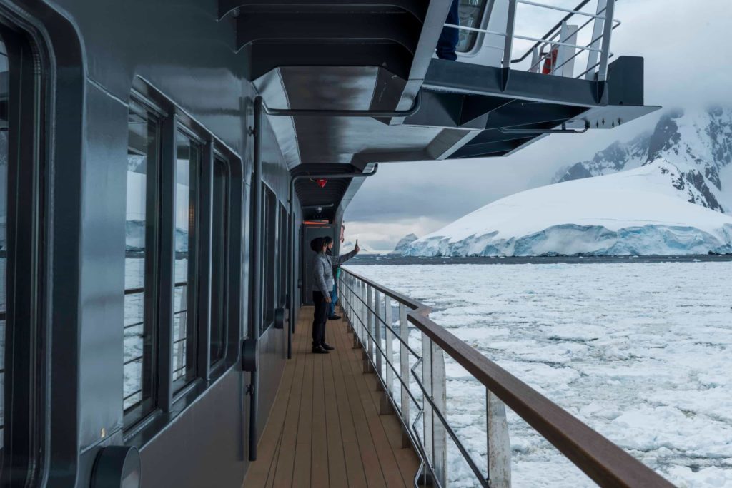 Panoramic view from a cruise ship deck, guests enjoying the atmosphere along the voyage