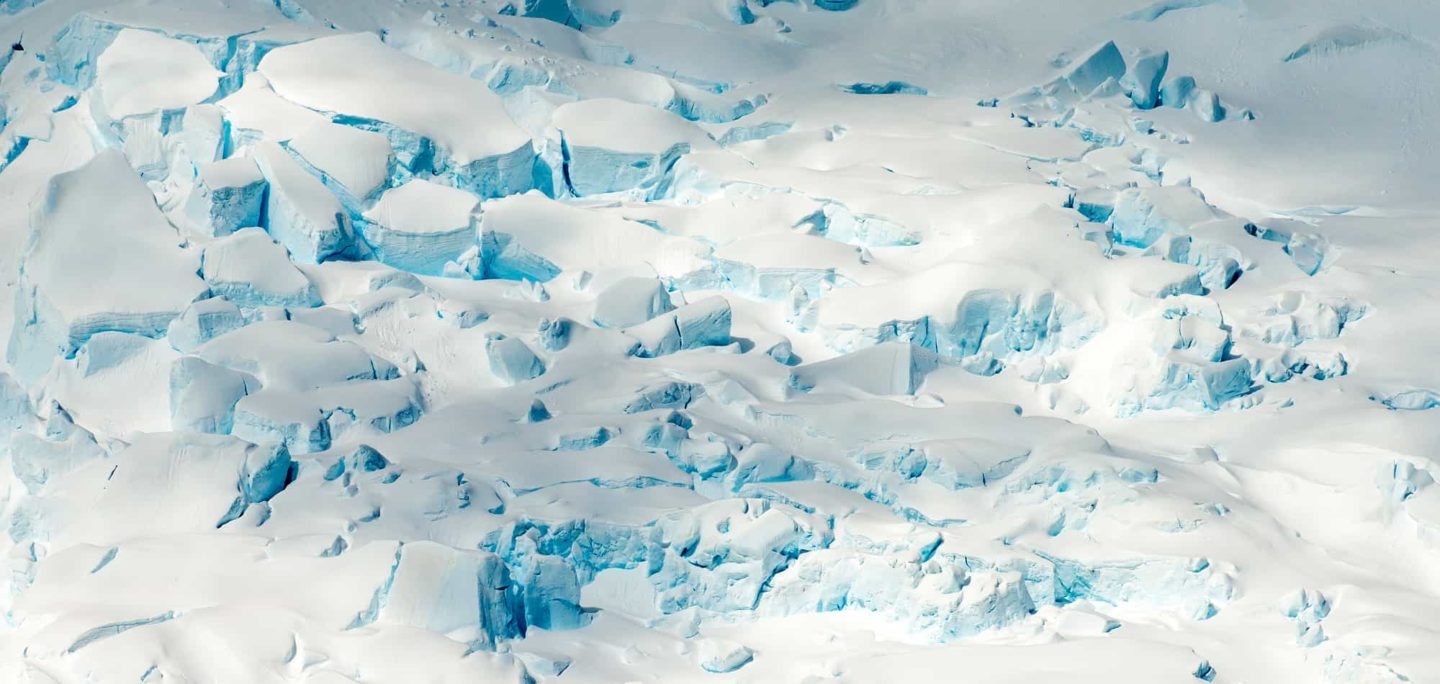 In the frozen vastness of Antarctica, the surface of an iceberg