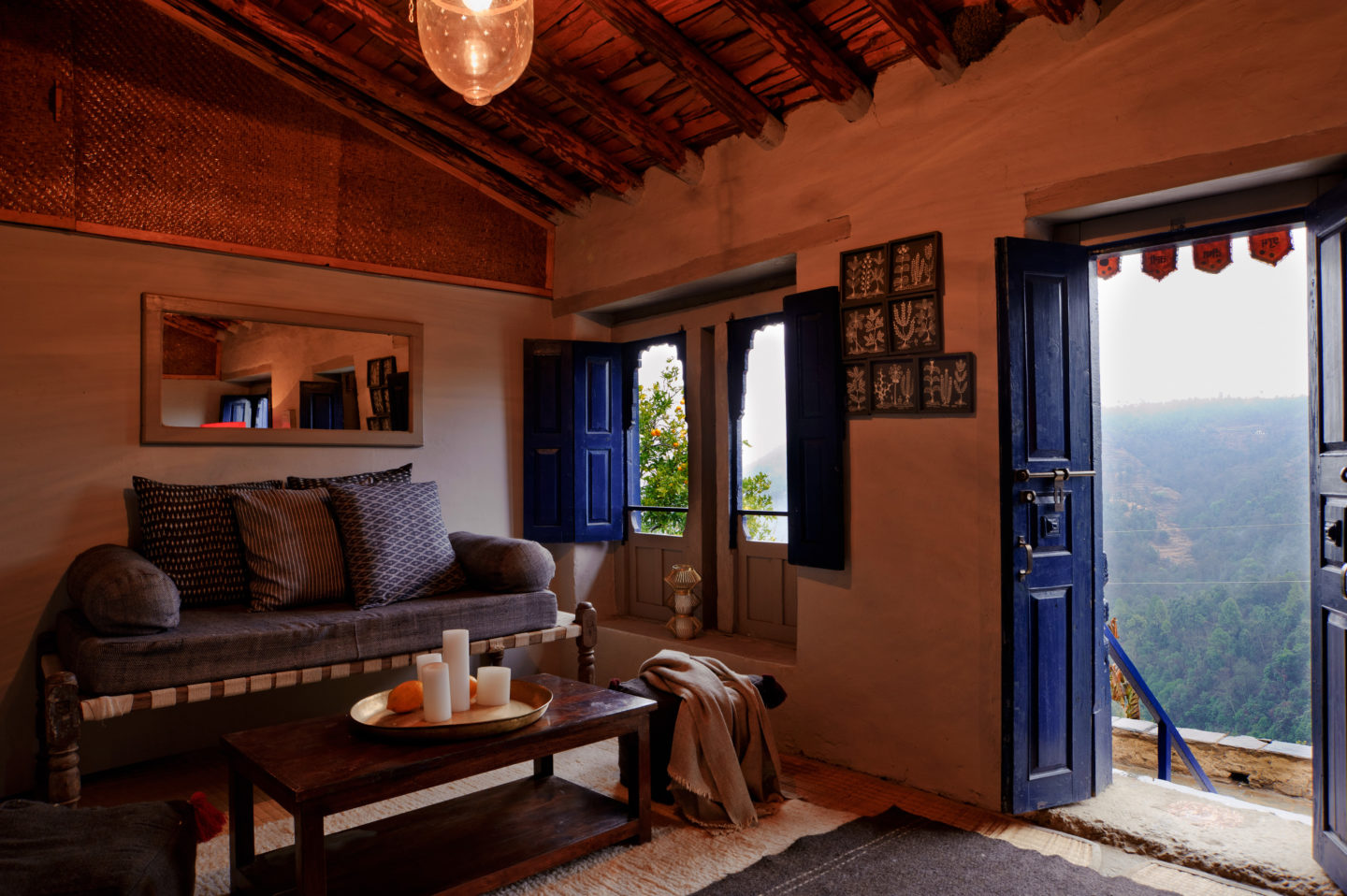 Living room with a traditional mountain-style aesthetic, and an open door with a scenic view