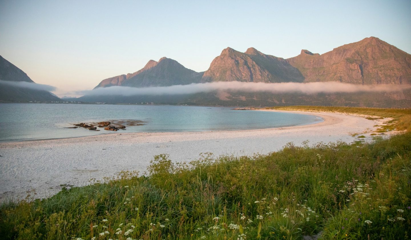 Scenic view of a white sand beach and mountains on the island of Vestvågøy