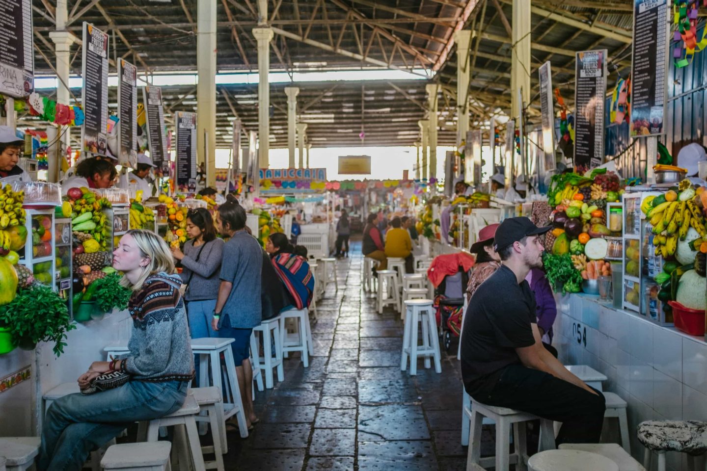 Market in Peru with people at tables enjoying fruit and juice