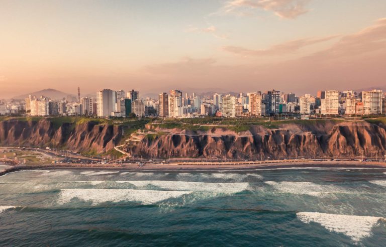 Lima city skyline on top of a cliff overlooking the Pacific Ocean at sunset