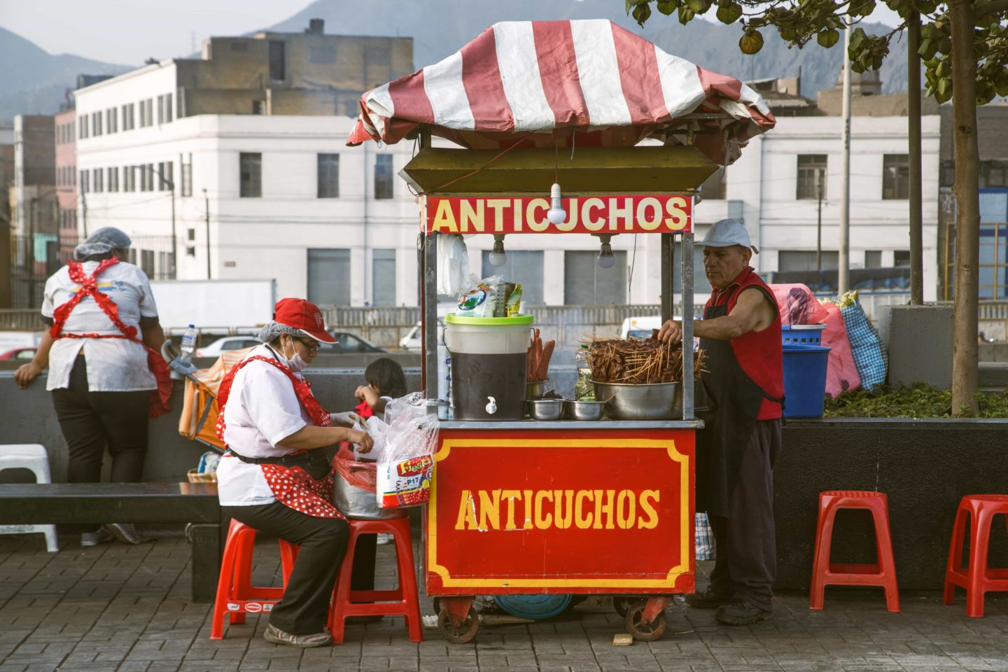 Chef and staff actively preparing meals at a street food stall in Peru