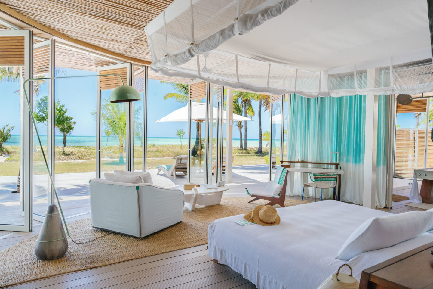 Bedroom in Miavana featuring a large glass door that opens to a stunning view of the ocean