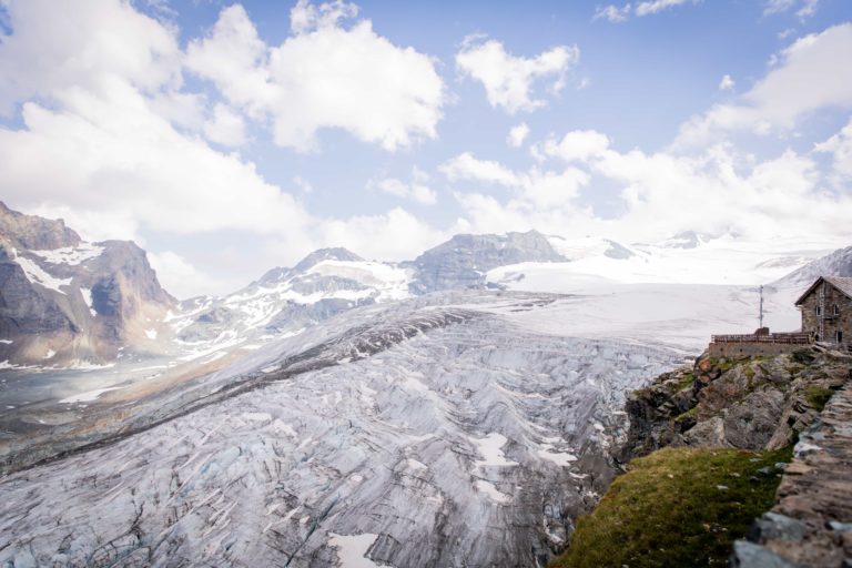 Mountain with a house perched on top, overlooking a glacier in Saas Fee