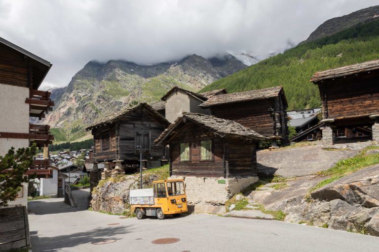 A scenic view of Saas-Fee with houses and a majestic mountain range