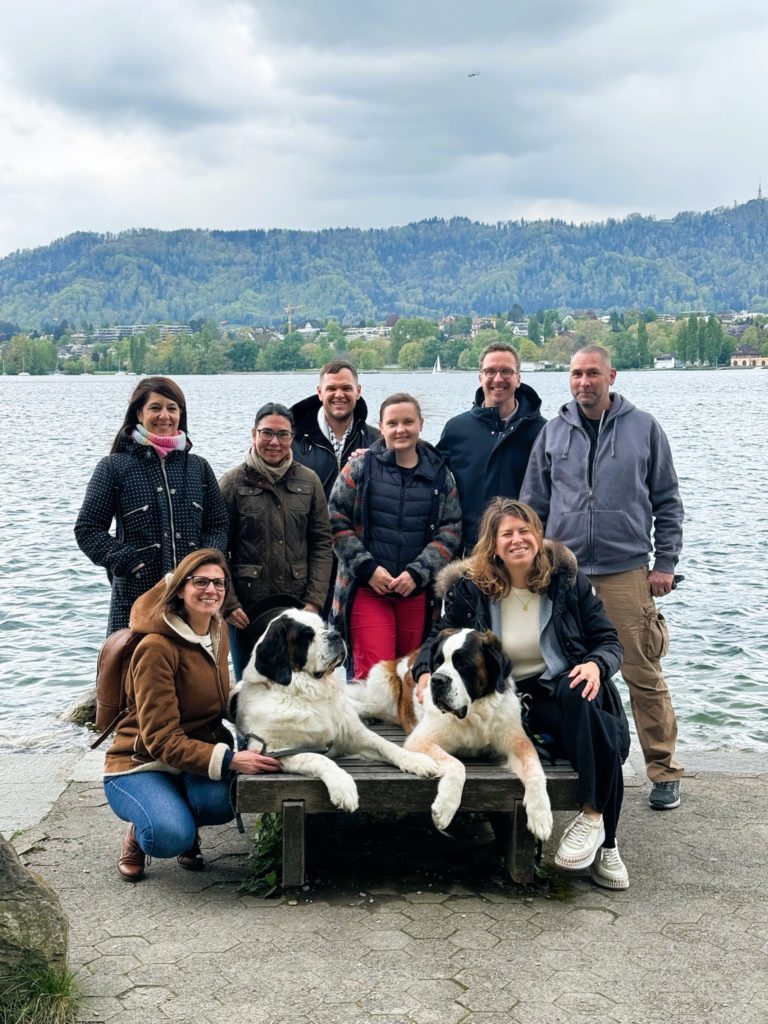 Cosa team gather for a cheerful photo with St. Bernard all with joyful expressions and a friendly atmosphere